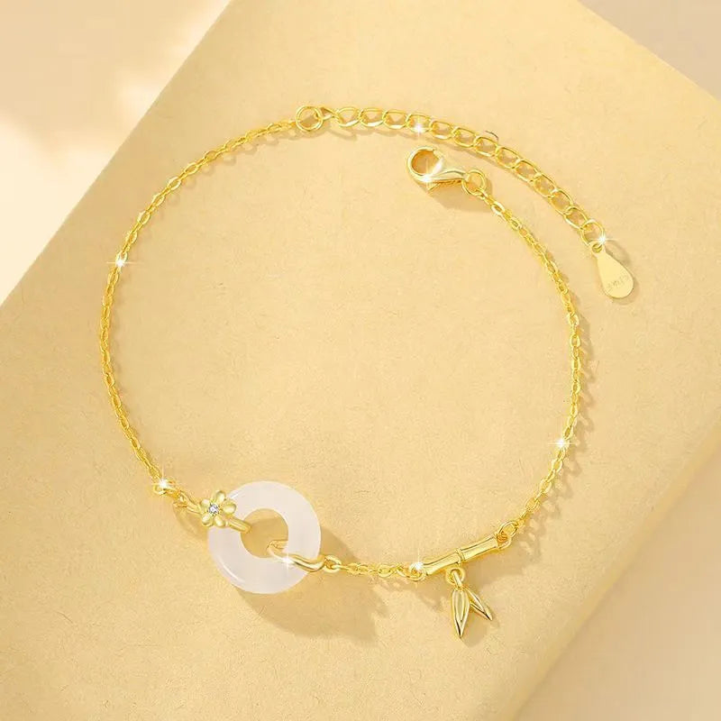 Women's silver and gold electroplated bracelet with peace buckle charm and white chalcedony stone.
