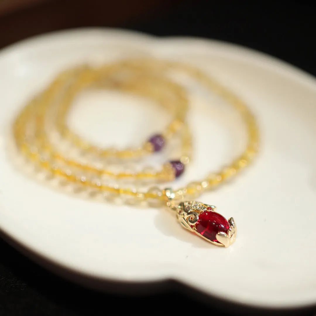 Natural gold rutilated quartz bracelet with Chinese style three circles and hanging chopsticks design.