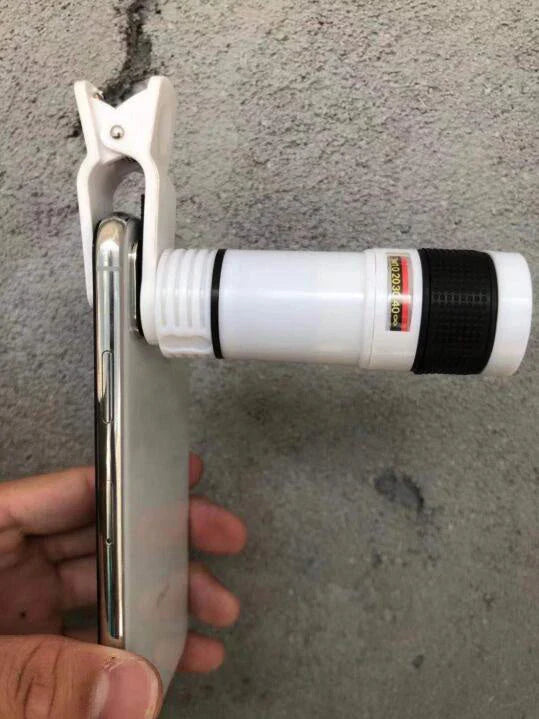 A close-up photograph of a telescope lens attached to a smartphone, capturing a distant subject with impressive clarity and detail.