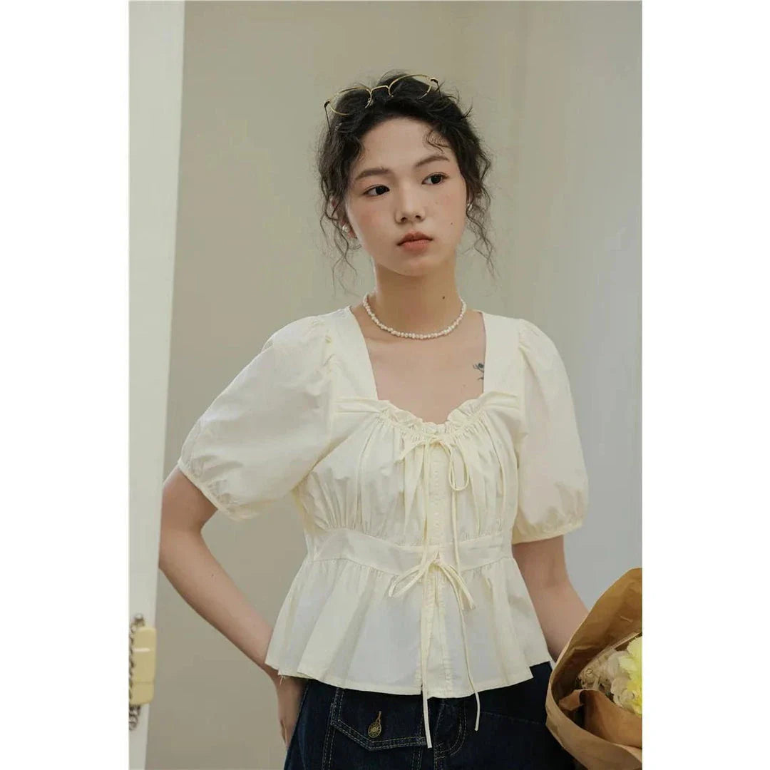 Elegant vintage white blouse with square neckline, puff sleeves, and lace-up detail