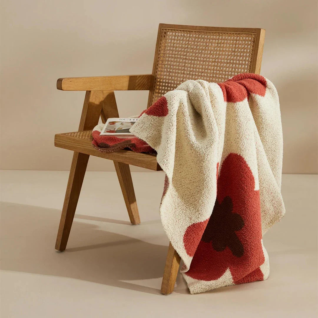 Cosy floral knitted throw blanket in red, grey, and orange shades - a high-quality microfibre accessory for year-round comfort and style