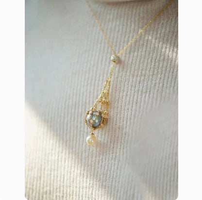 Elegant shell bead necklace with 18K gold plating and a delicate net crystal pendant