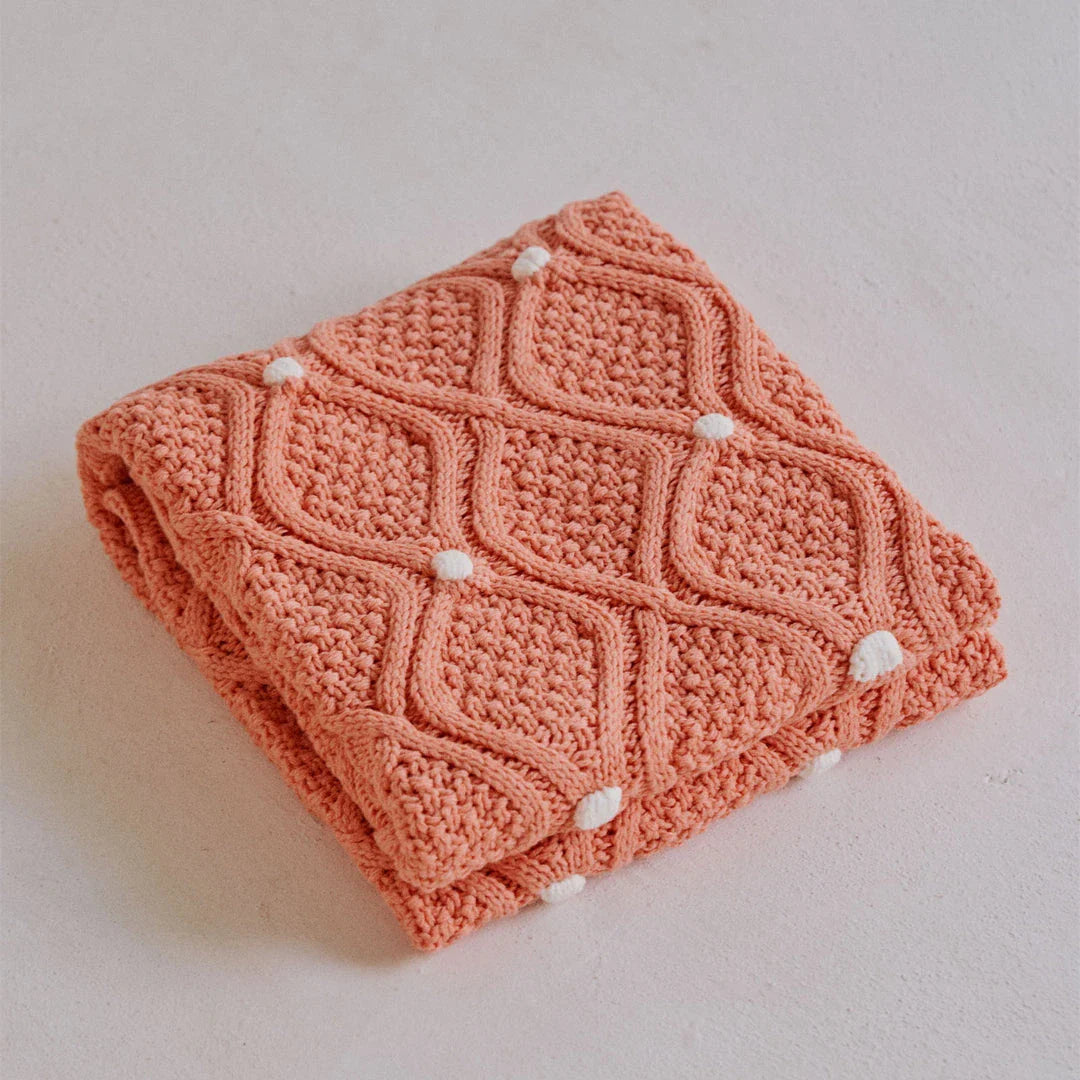 Cosy chunky knit blanket with charming pompoms in multiple sizes and colours for elegant home décor