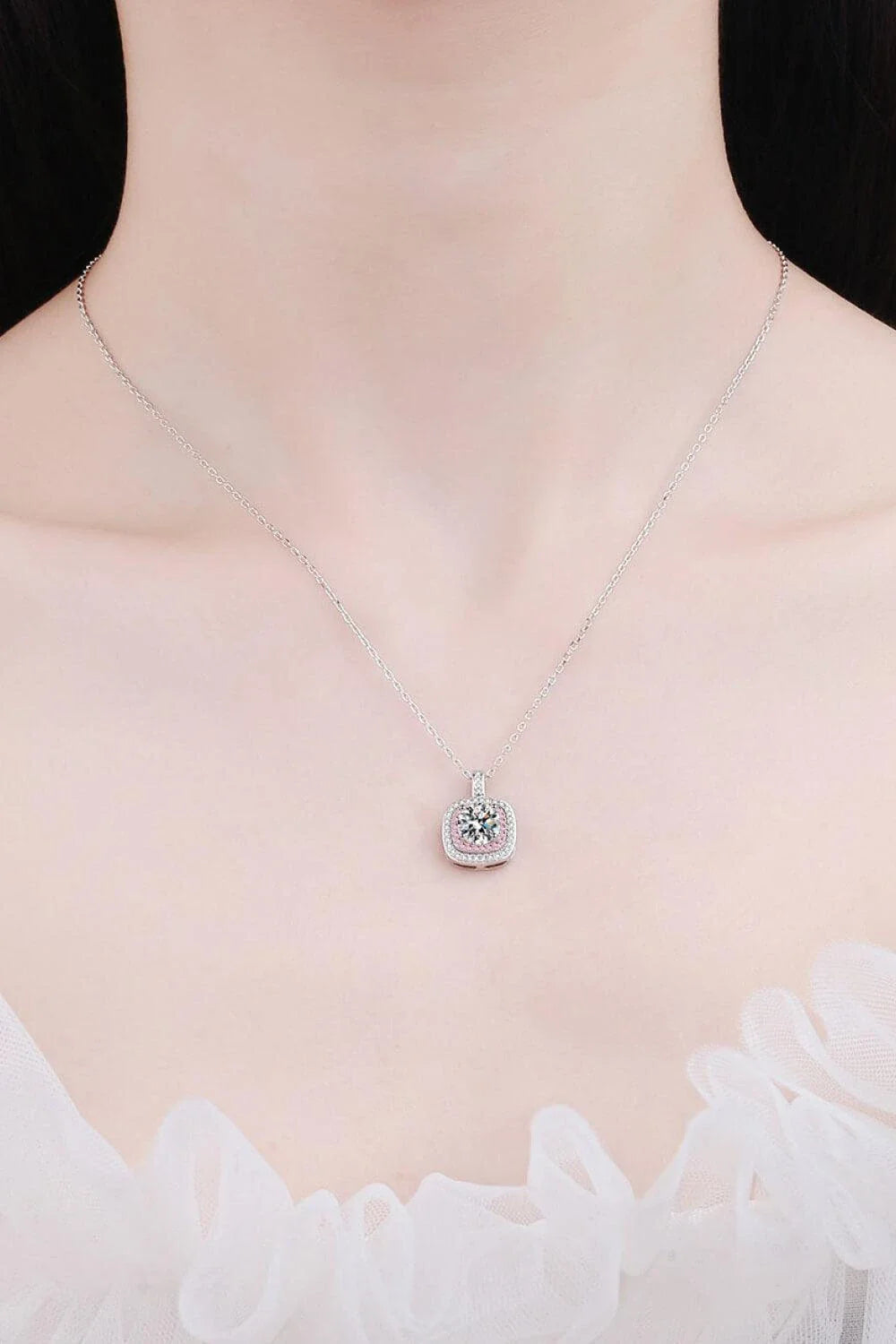 A rhodium-plated sterling silver necklace with a geometric pendant featuring a sparkling Moissanite gemstone over 0.3 carats.