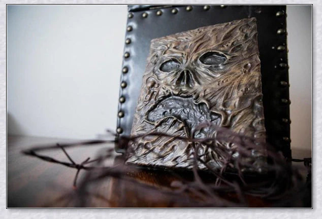 A haunting Necronomicon book with an embossed monster cover, aged pages, and a leathery, deathly texture
