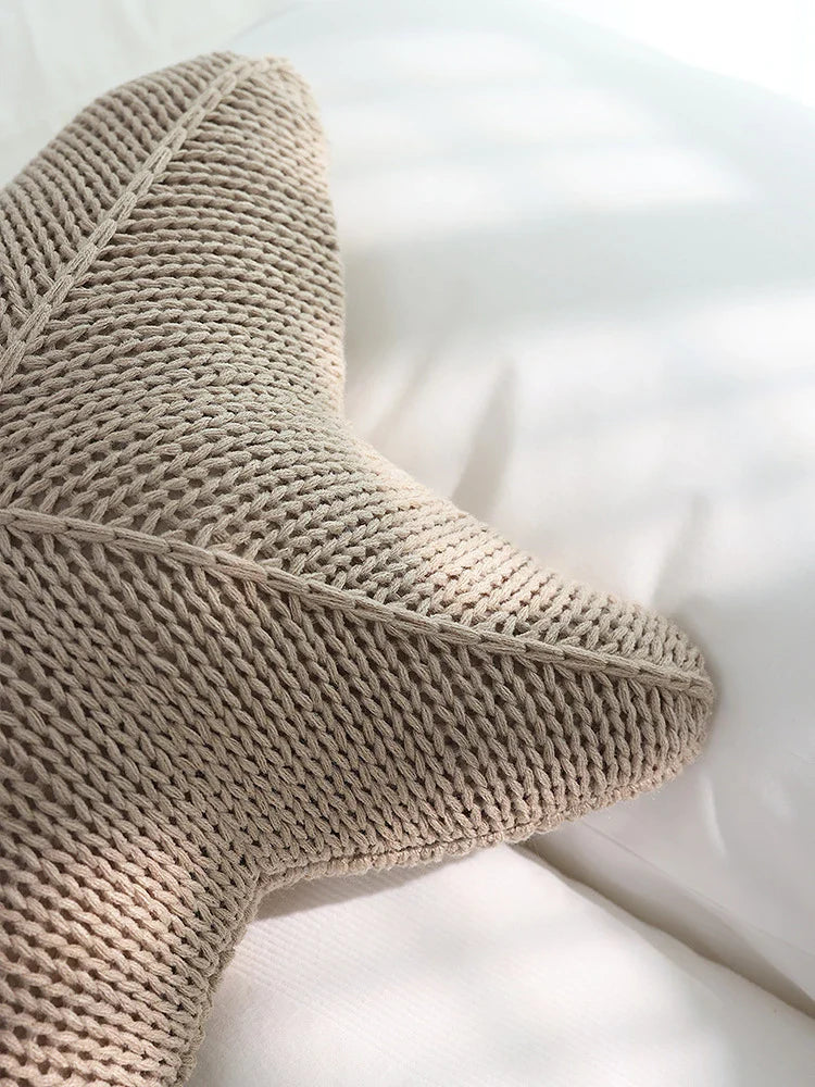 Artfully hand-knitted starfish-shaped cushion in a range of sophisticated colour options, providing plush comfort and coastal charm for any living space.