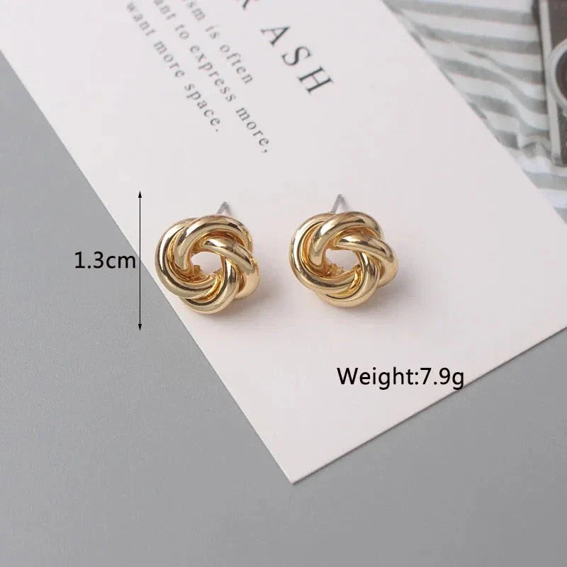 Elegant geometric statement earrings with a luxurious gold finish, featuring a unique hollow twist design.
