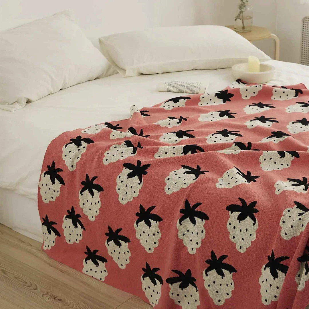 A cosy grape-patterned cotton blanket with a sophisticated design, perfect for relaxation and home decor