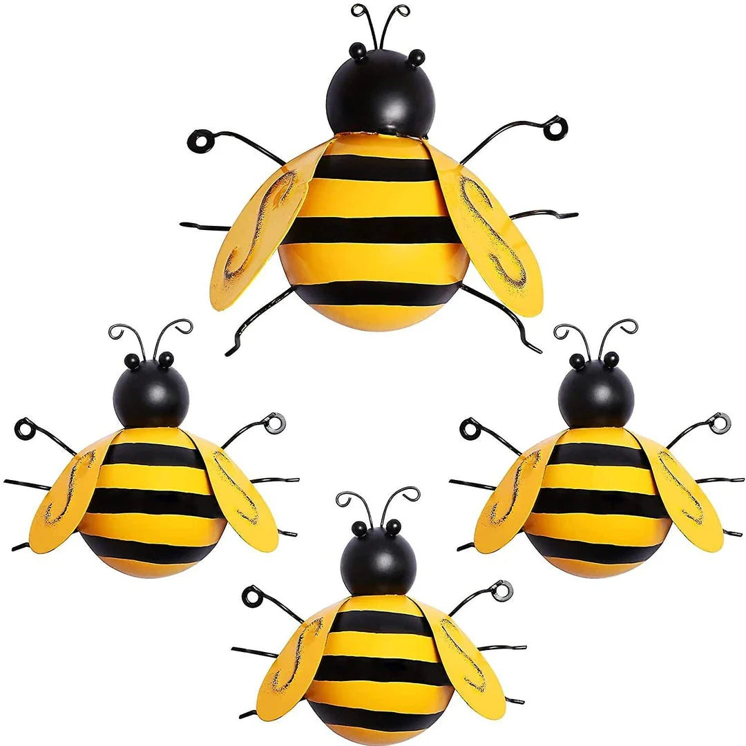 Four decorative metal bumble bee sculptures in a natural garden setting
