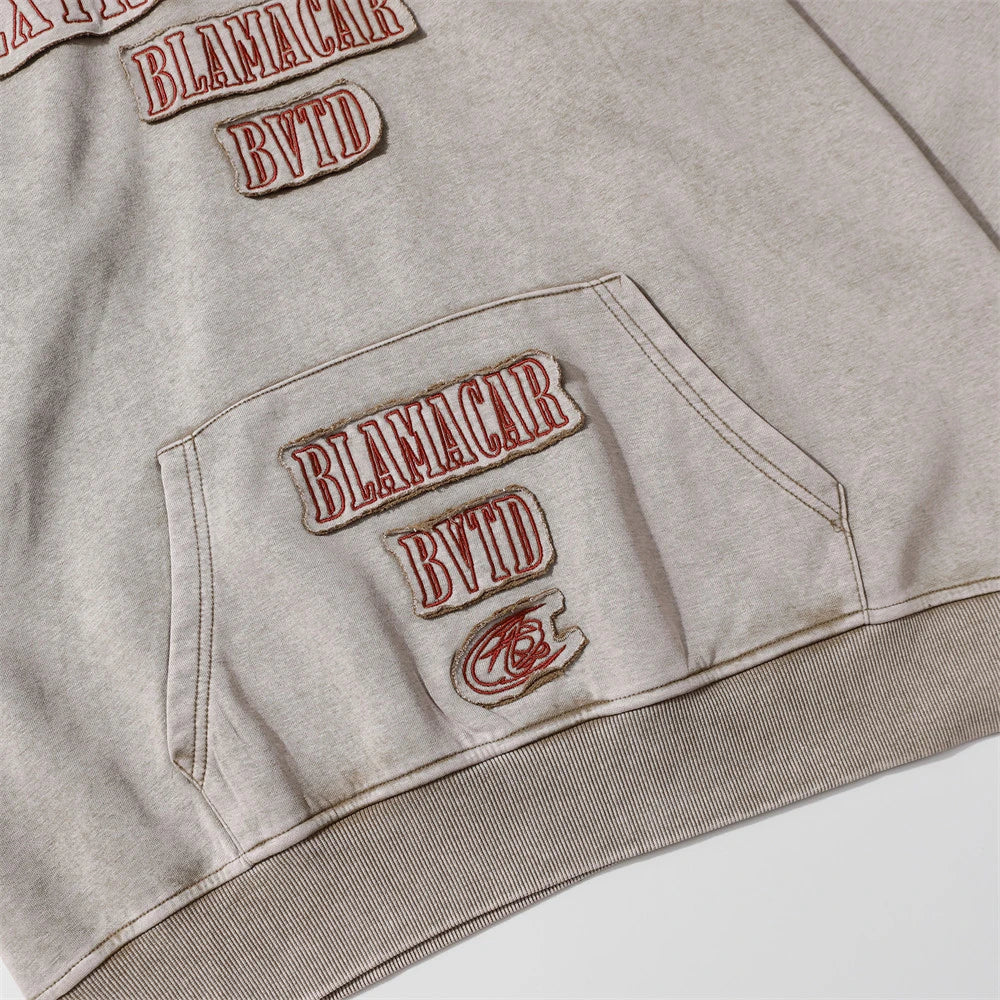 A premium cotton pullover hoodie with an embroidered letter patch in a variety of classic autumn colours