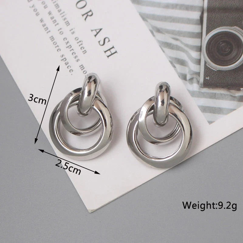 Elegant geometric statement earrings with a luxurious gold finish, featuring a unique hollow twist design.