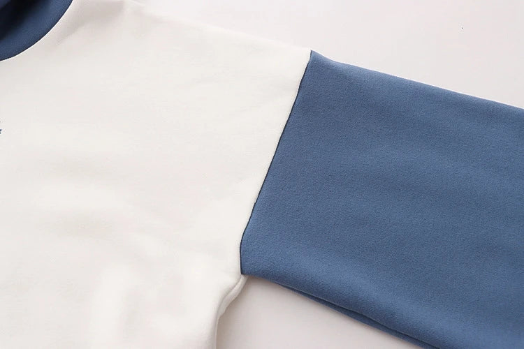 A cosy, velvet-padded hooded sweater with playful alphabet sleeves in pink and blue colours