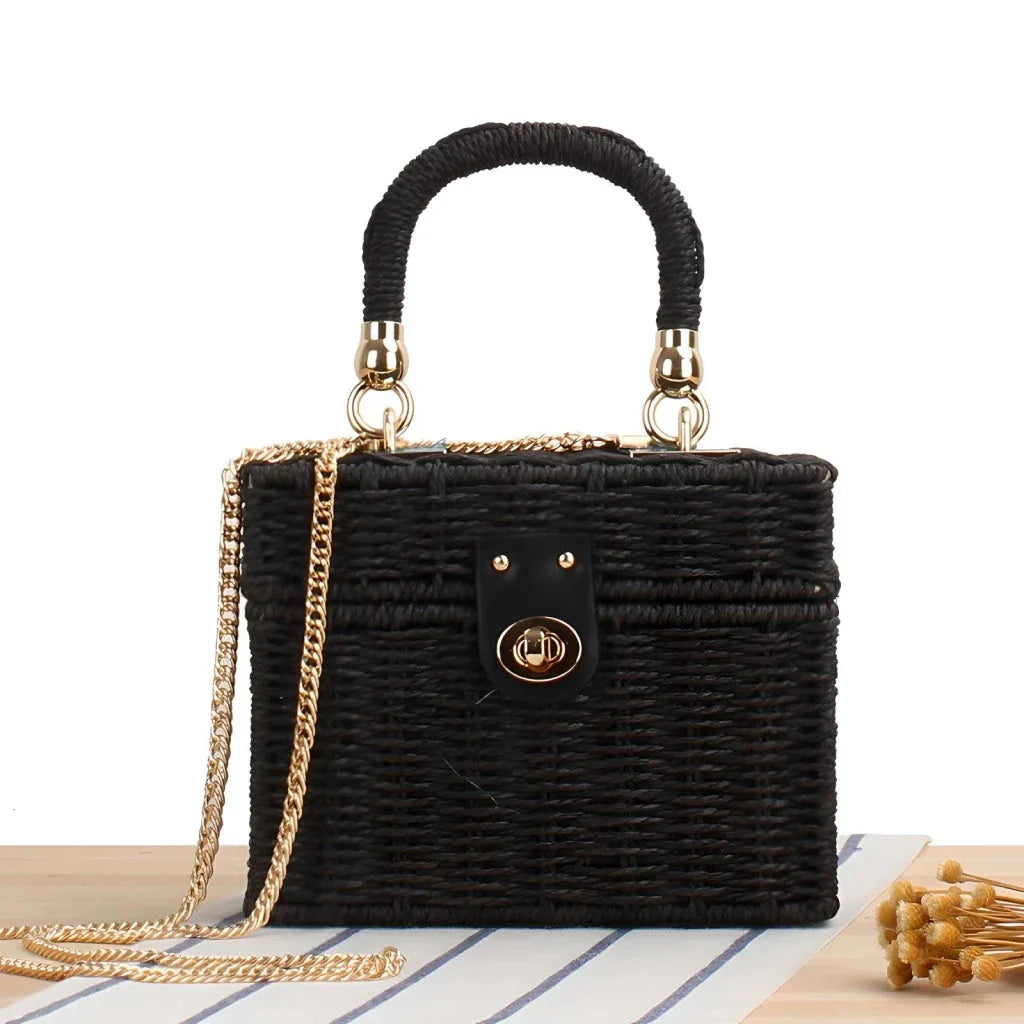 Handcrafted natural straw beach bag with bohemian-inspired design and detachable metal chain strap