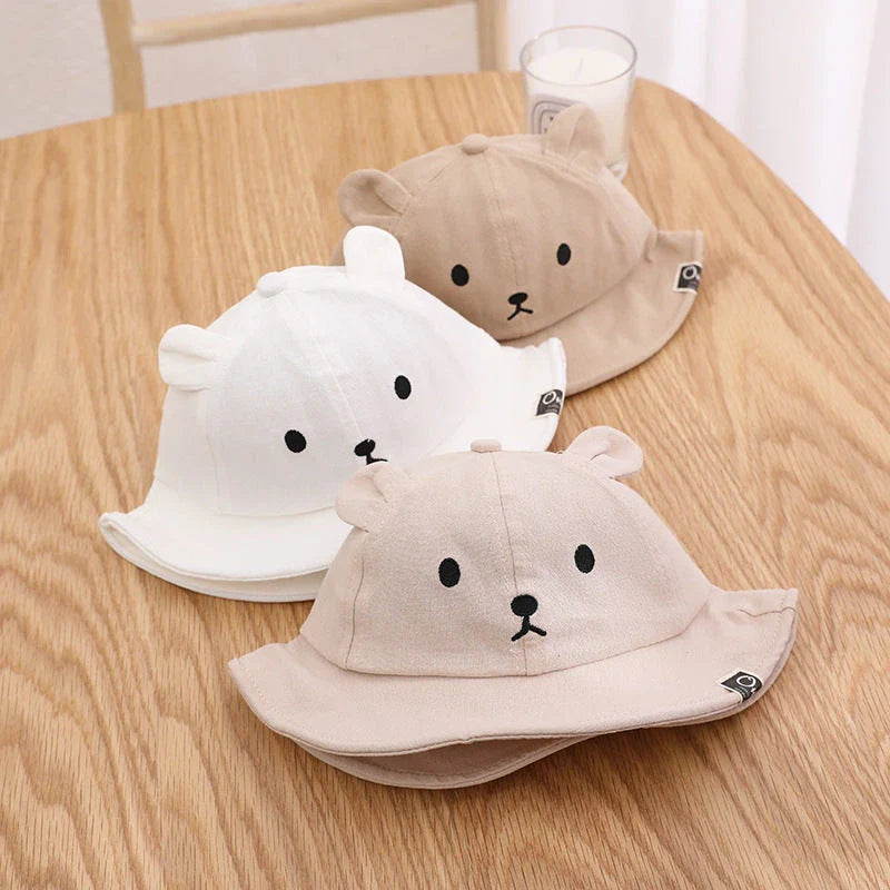 Adorable baby sun hat with cute bear ears, made of soft cotton and durable polyester for sun protection and comfort.