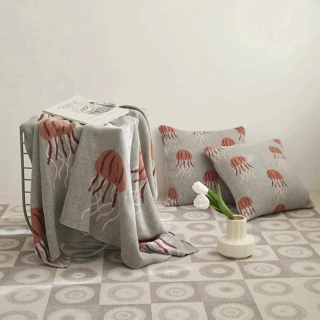 Cosy jellyfish-patterned cotton knit throw blanket in green and grey colours, showcasing its soft, plush texture and unique design.