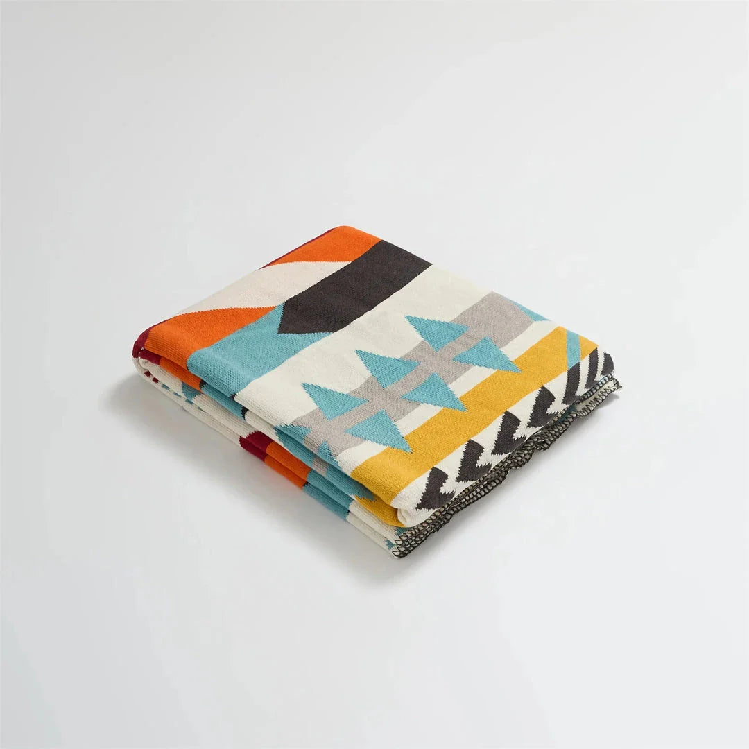 Cosy bohemian-style cotton blanket with vibrant geometric pattern, suitable for indoor and outdoor use