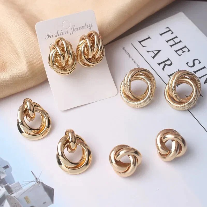 Elegant geometric statement earrings with a luxurious gold finish, featuring a unique hollow twist design.