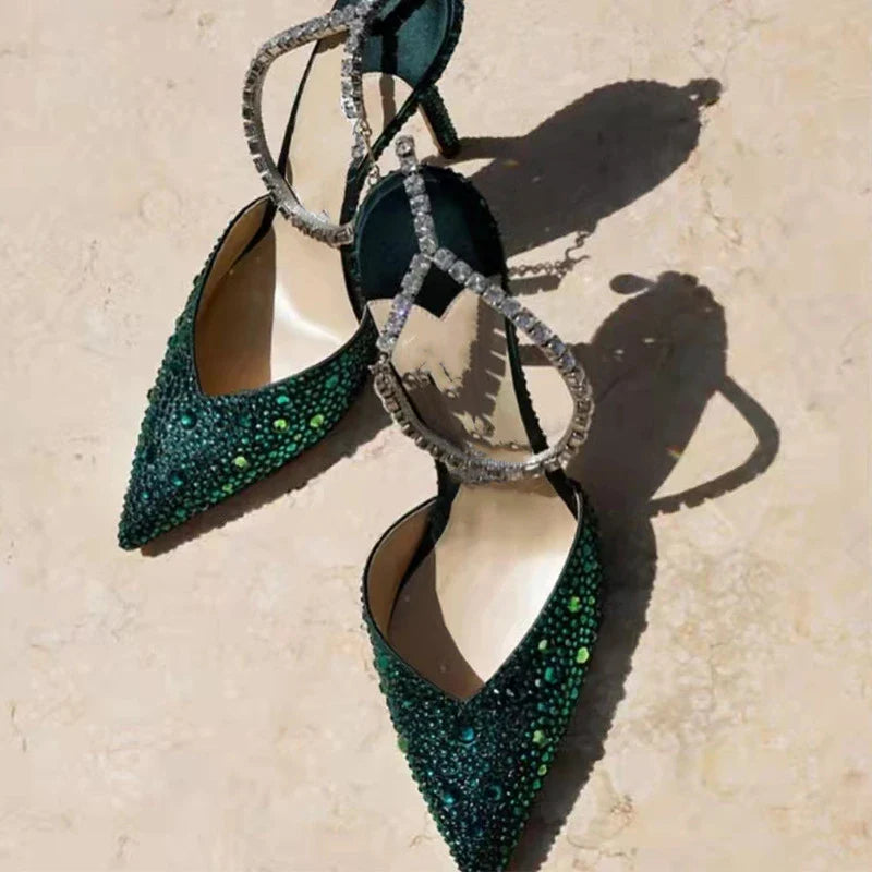 Elegant stiletto sandals with rhinestone chain embellishment, showcasing a sleek pointed toe design and matte finish for a sophisticated British-inspired look.