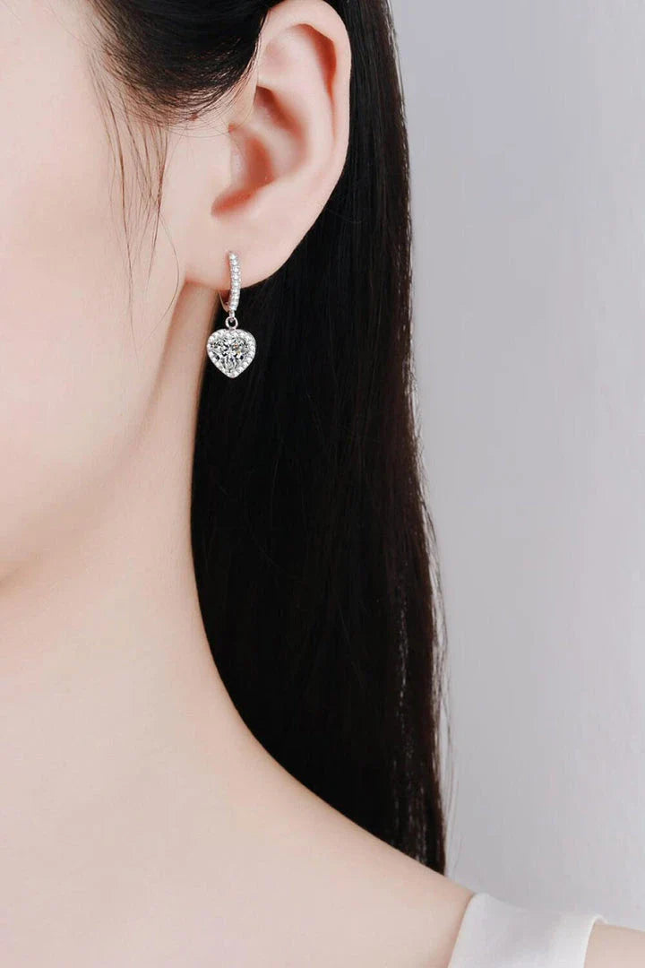 A pair of elegant moissanite heart-shaped drop earrings with a brilliant 2-carat display, crafted in 925 sterling silver with rhodium plating and zircon accents.