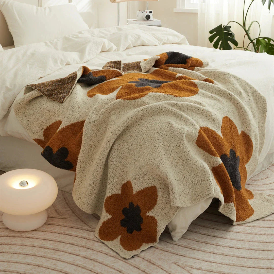 Cosy floral knitted throw blanket in red, grey, and orange shades - a high-quality microfibre accessory for year-round comfort and style