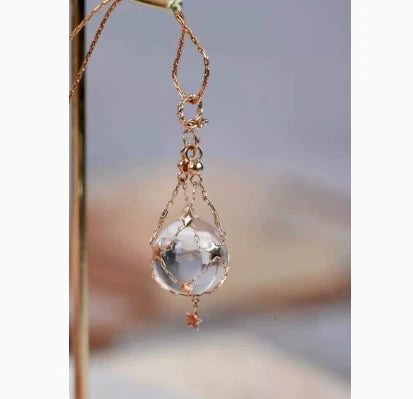 Elegant shell bead necklace with 18K gold plating and a delicate net crystal pendant