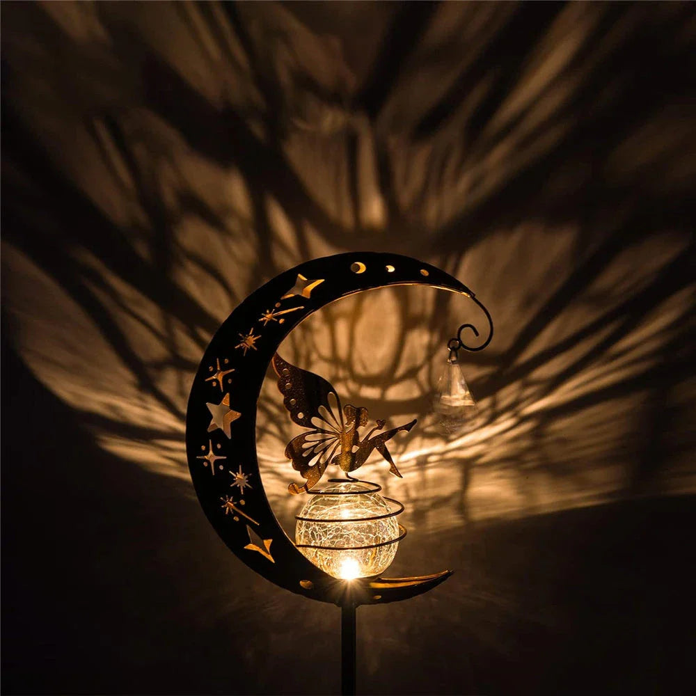 Decorative solar-powered garden light with a fairy and moon design, providing enchanting illumination for pathways, patios, and lawns.