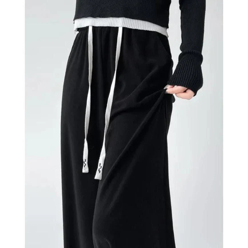 Elegant high-waist drawstring trousers in black, featuring a wide-leg cut and stylish lace-up pockets