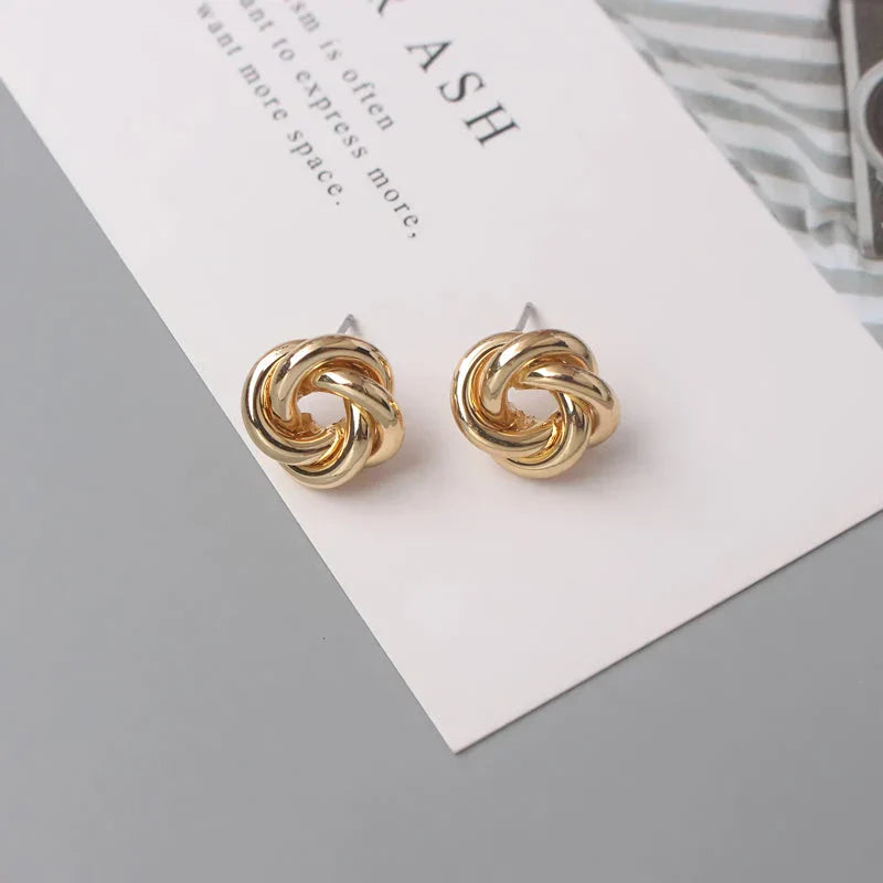 Elegant geometric statement earrings with a luxurious gold finish, featuring a unique hollow twist design.
