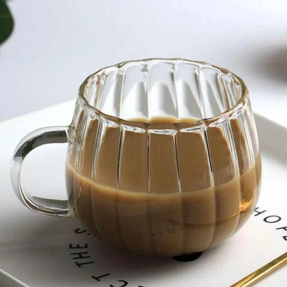 A set of heat-resistant glass mugs featuring a charming pumpkin pattern design, perfect for cosy UK mornings.