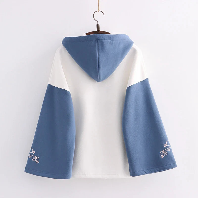 A cosy, velvet-padded hooded sweater with playful alphabet sleeves in pink and blue colours