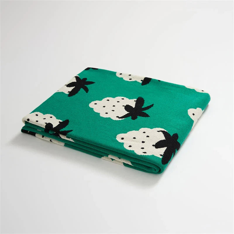 A cosy grape-patterned cotton blanket with a sophisticated design, perfect for relaxation and home decor