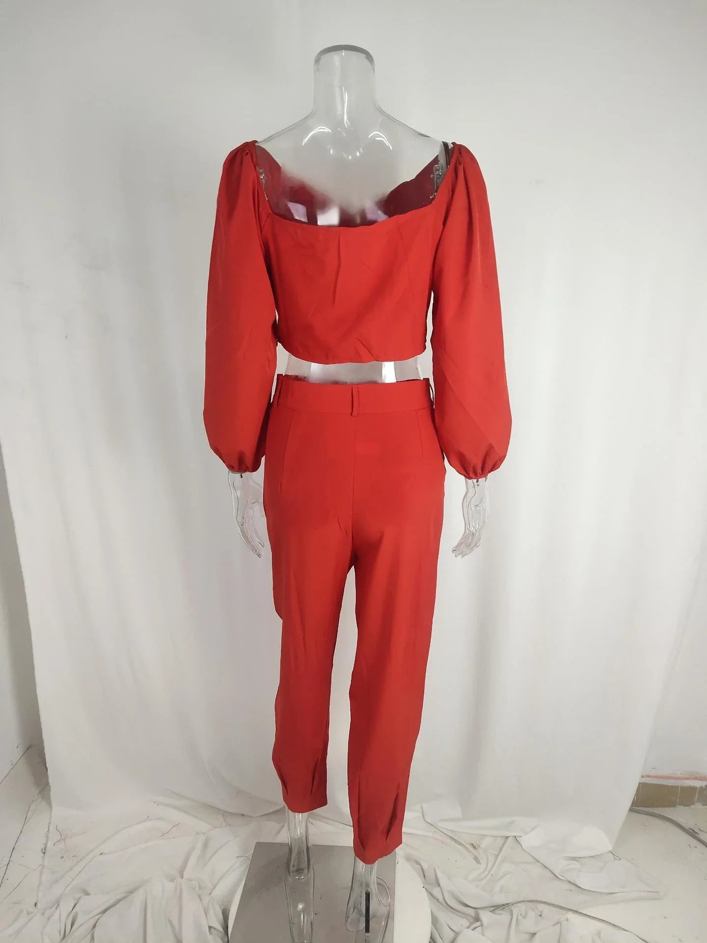 A stylish two-piece set with a square neckline top and ankle-tie trousers, made of premium polyester fabric and available in a range of vibrant solid colours.