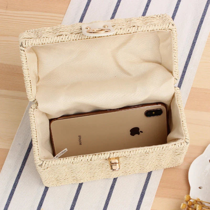 Handcrafted natural straw beach bag with bohemian-inspired design and detachable metal chain strap