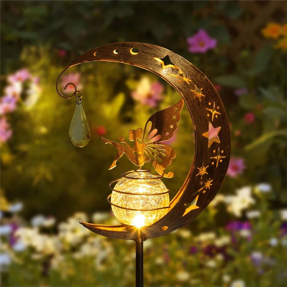 Decorative solar-powered garden light with a fairy and moon design, providing enchanting illumination for pathways, patios, and lawns.