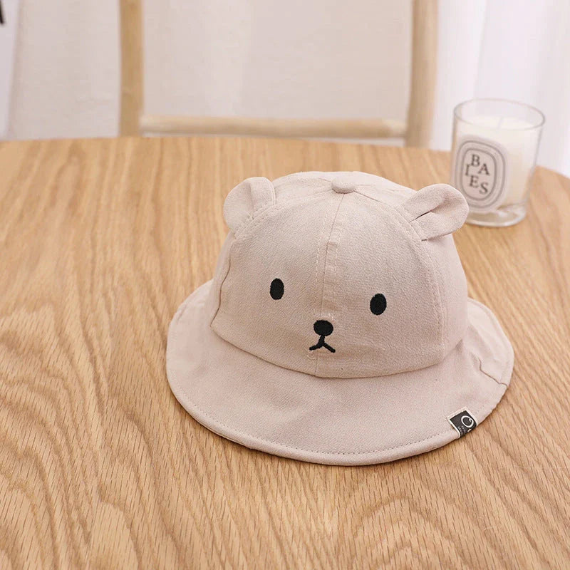 Adorable baby sun hat with cute bear ears, made of soft cotton and durable polyester for sun protection and comfort.