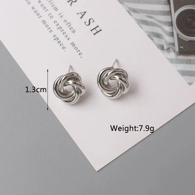 Elegant geometric statement earrings with a luxurious gold finish, featuring a unique hollow twist design.