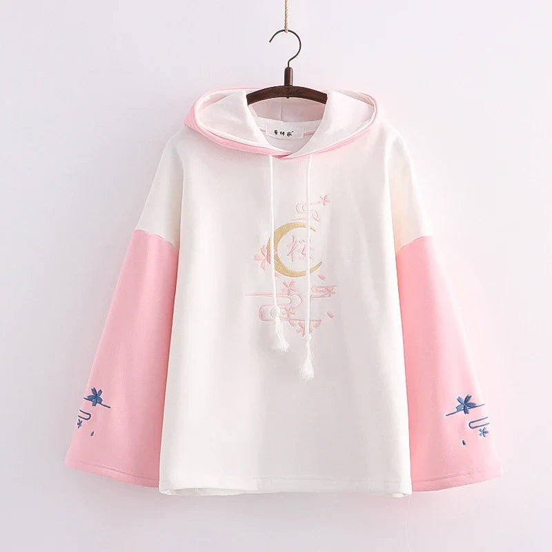 A cosy, velvet-padded hooded sweater with playful alphabet sleeves in pink and blue colours