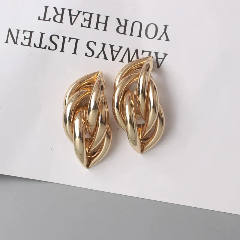Elegant geometric statement earrings with a luxurious gold finish, featuring a unique hollow twist design.