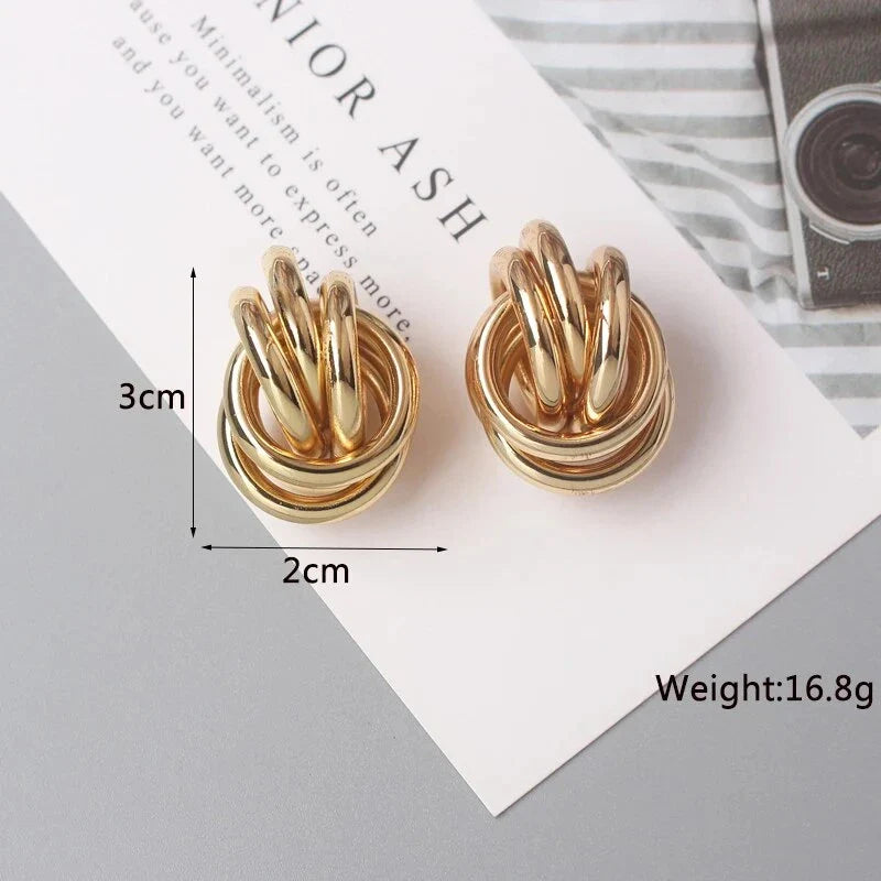 Elegant geometric statement earrings with a luxurious gold finish, featuring a unique hollow twist design.