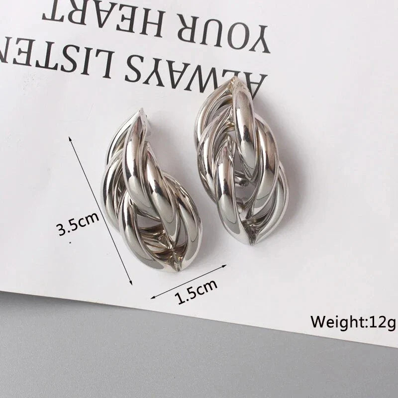 Elegant geometric statement earrings with a luxurious gold finish, featuring a unique hollow twist design.