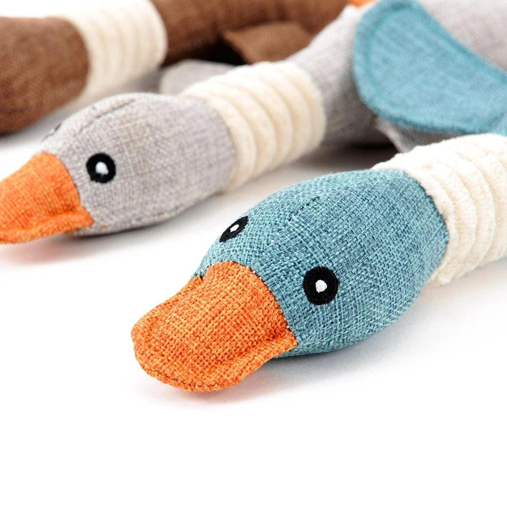 A soft, plush duck toy designed for dogs, featuring a squeaky component to encourage playful interaction.