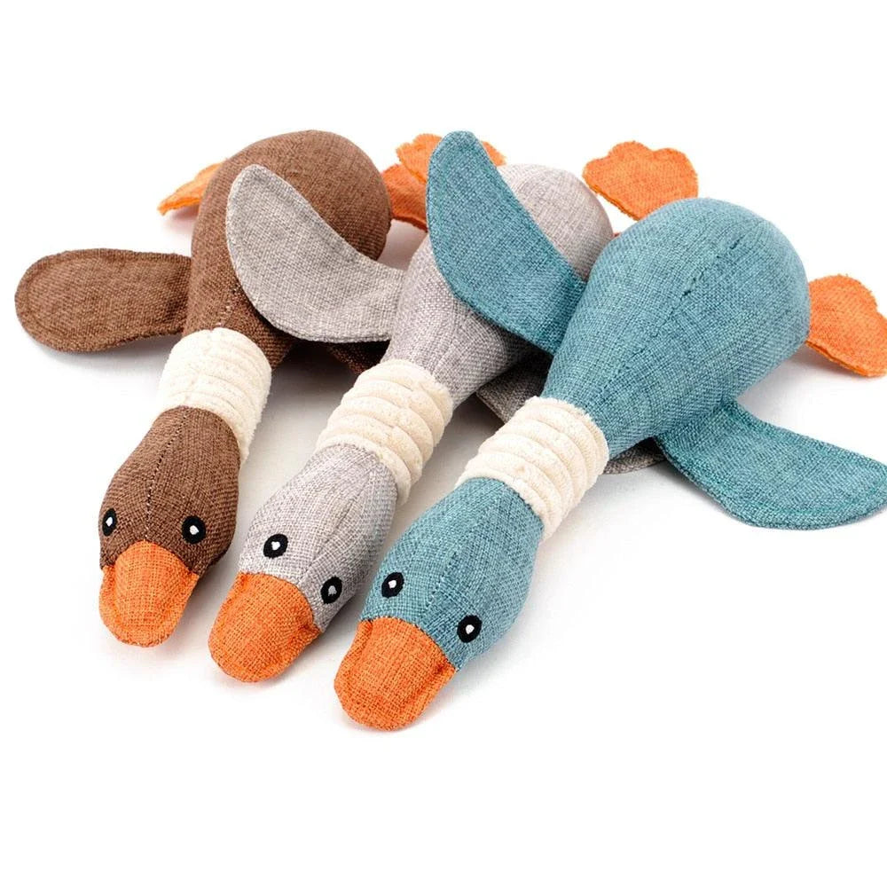 A soft, plush duck toy designed for dogs, featuring a squeaky component to encourage playful interaction.