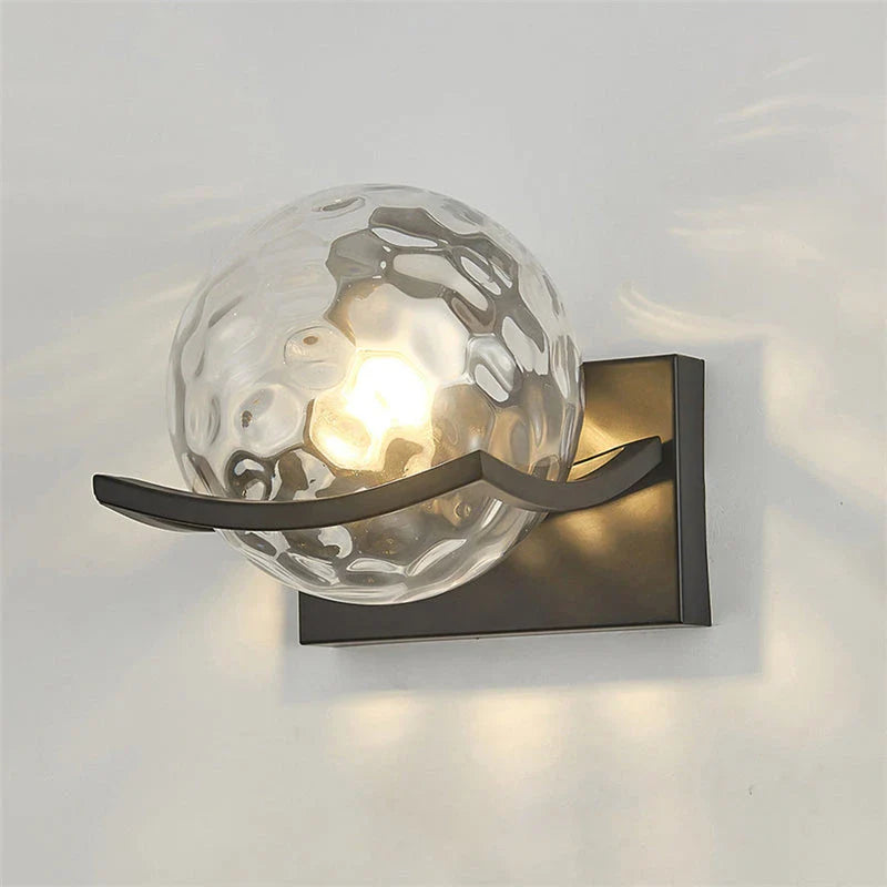 Modern black iron wall lamp with clear glass shade and LED lighting for a sophisticated look