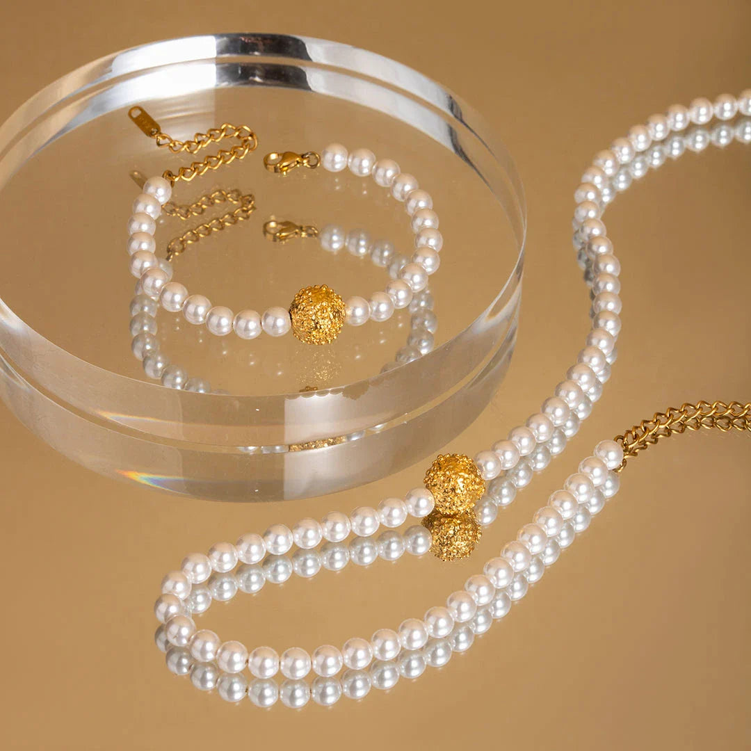 An elegant 18K gold-plated stainless steel bracelet featuring a flower ball design with a lustrous pearl centre