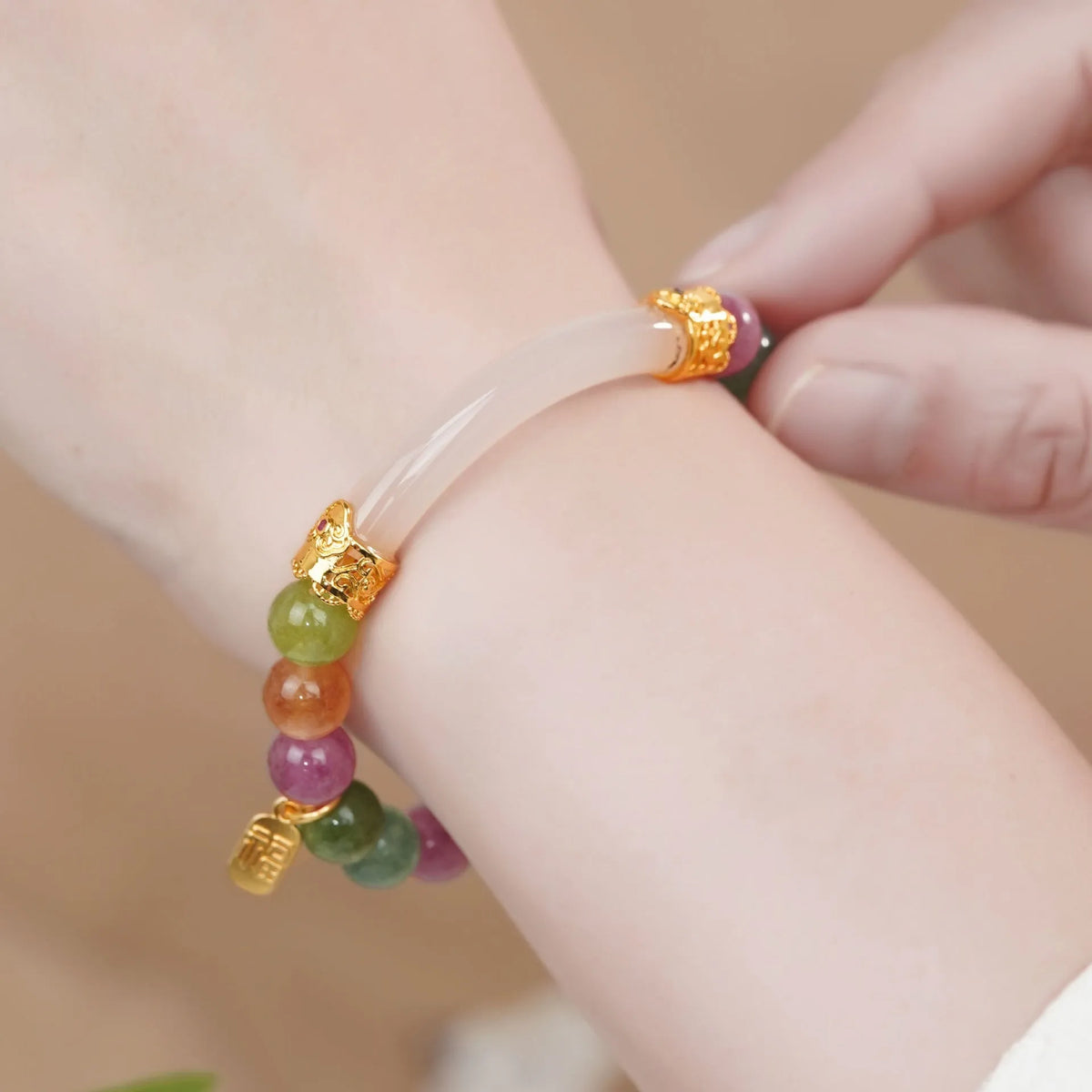 Rainbow-coloured tourmaline half bracelet for women on a wrist.