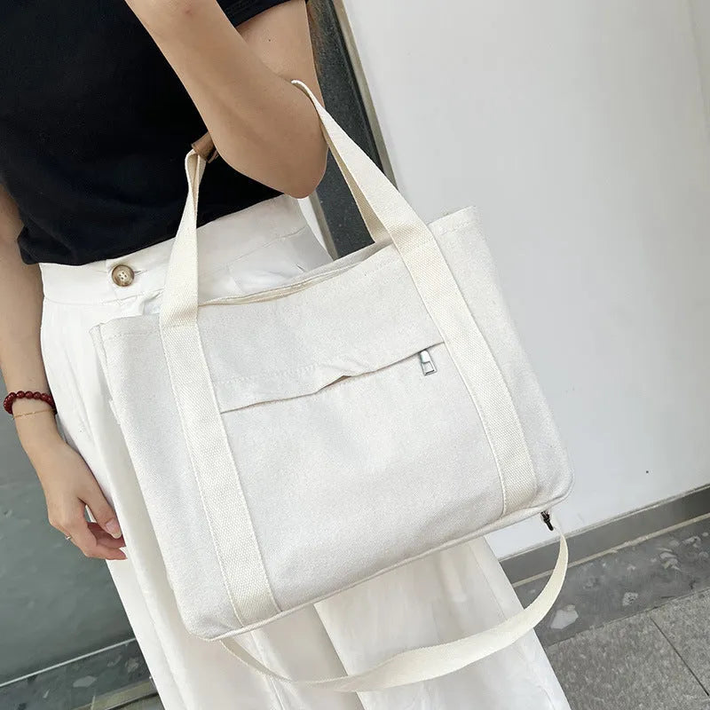 Large canvas tote bag in horizontal square shape with open-zip sides and internal organisers
