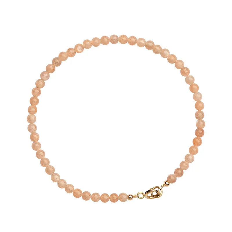 Women's ultra-thin 3mm Sunstone bead bracelet on wrist, showing natural crystal and delicate design.
