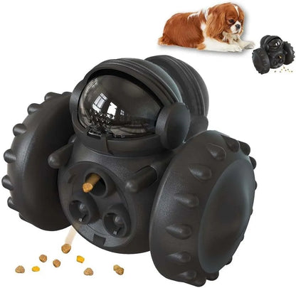 A black, robot-shaped treat dispenser toy for dogs and cats on a wooden floor, showing its size and rolling design.