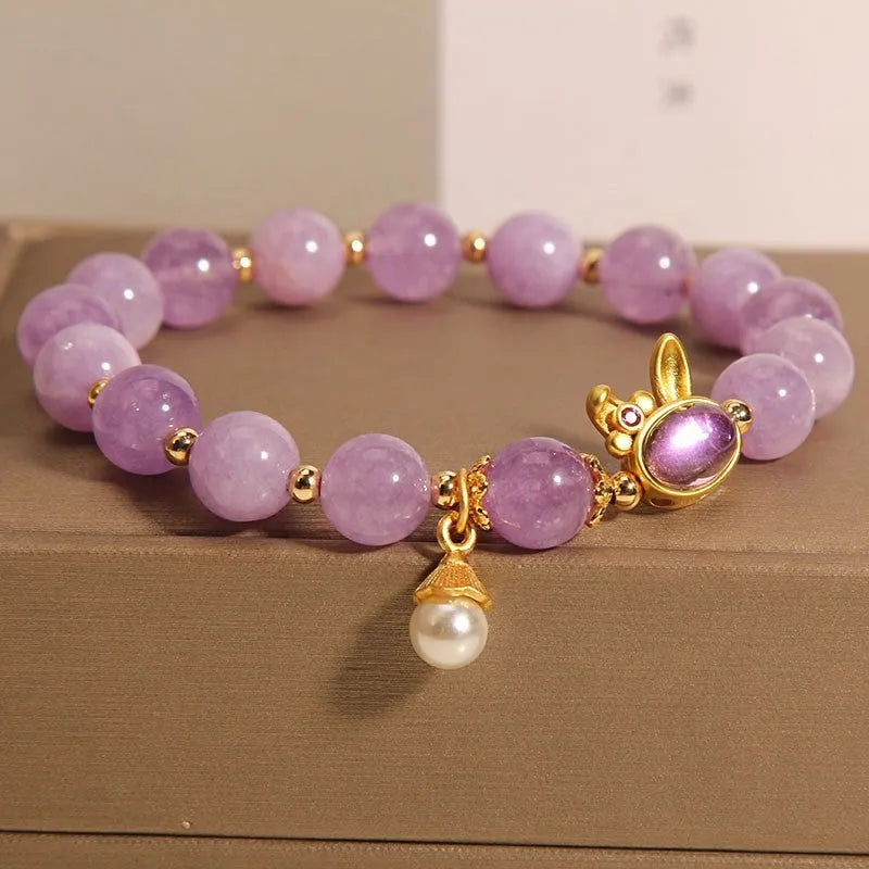 Natural mauve jade rabbit head charm bracelet with crystal details on wrist.