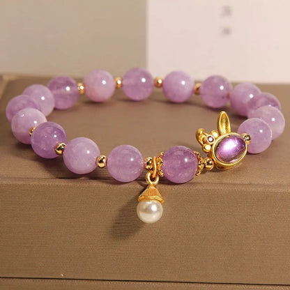 Natural mauve jade rabbit head charm bracelet with crystal details on wrist.